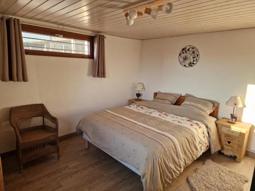 a bedroom with a bed and a chair and a clock at Studio Bellevue appart indépendant rénové 2024 piscine parking proche centre Annecy in Poisy