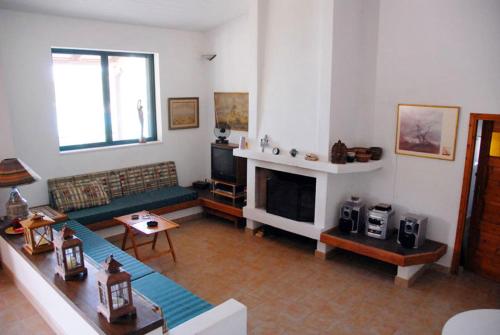 een woonkamer met een bank en een open haard bij Cottage by the sea in Áyios Dhimítrios