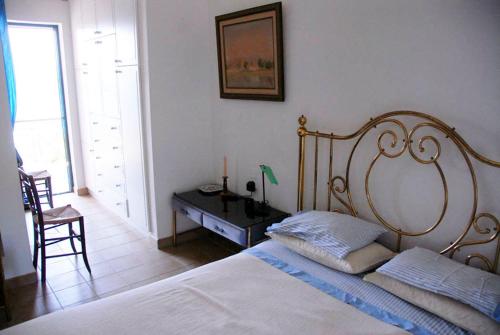 een slaapkamer met een bed en een bureau met een lamp bij Cottage by the sea in Áyios Dhimítrios
