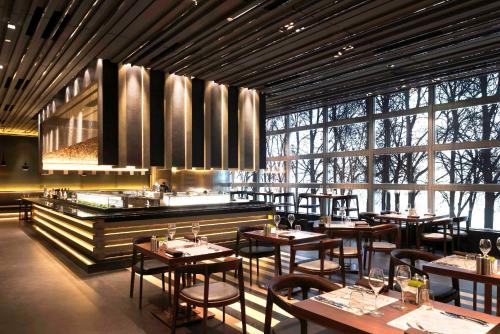 香港にあるNina Hotel Kowloon Eastの大きな窓のある部屋(テーブルと椅子付)