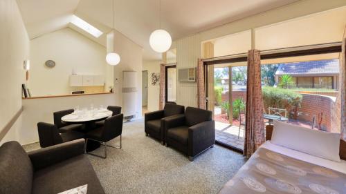 a living room with a couch and chairs and a table at Executive Hideaway in Benalla