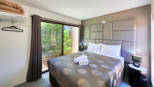 um quarto com uma cama grande e uma janela em Executive Hideaway em Benalla