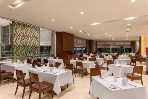 a dining room with white tables and chairs at Ramada Plaza By Wyndham Istanbul Tekstilkent in Istanbul