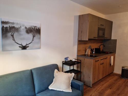 a living room with a blue couch and a kitchen at The Lodge at Bad Gastein in Bad Gastein