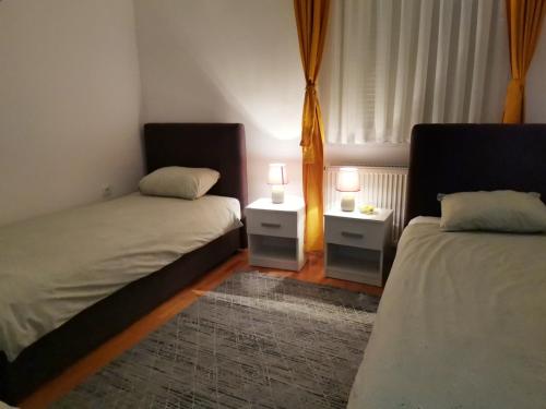 sypialnia z 2 łóżkami i 2 lampkami na stołach w obiekcie Apartment Mademoiselle w mieście Wiszegrad