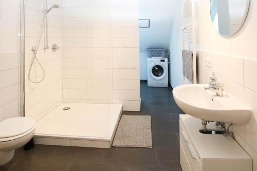 a bathroom with a toilet sink and a washing machine at Spacious Apartment with Balcony & WiFi in Wetzlar