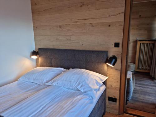 a bedroom with a bed with a wooden wall at The Lodge at Bad Gastein in Bad Gastein
