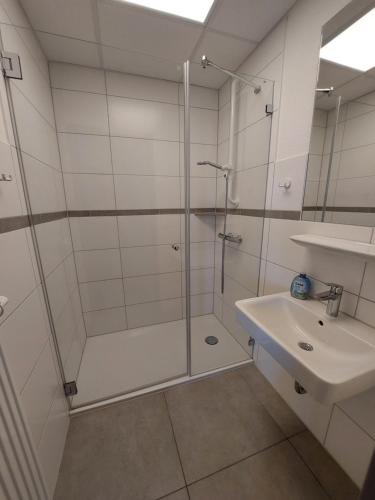 ein Bad mit einer Dusche und einem Waschbecken in der Unterkunft CVJM Freizeithaus MS Waterdelle in Borkum