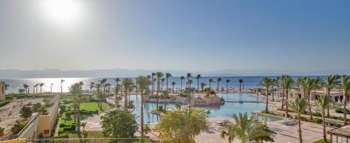 - une vue aérienne sur un complexe avec une piscine et des palmiers dans l'établissement Mosaique Beach Resort Taba Heights, à Taba