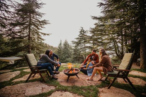a group of people sitting around a fire pit at Cedar Scent Guesthouse in Batroûn