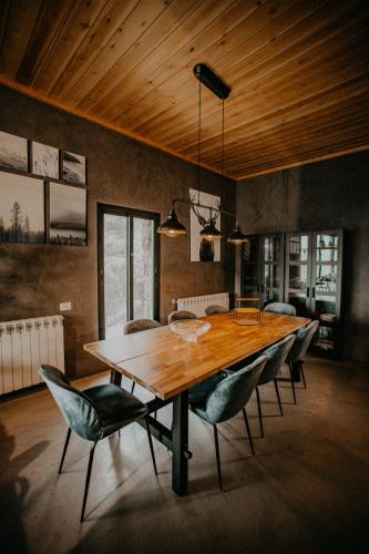 a dining room with a wooden table and chairs at Cedar Scent Guesthouse in Batroûn