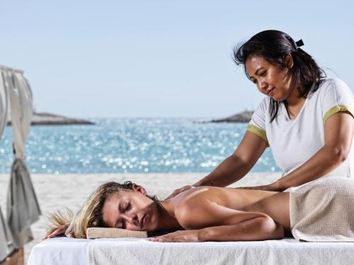 a woman getting a massage at the beach at Juweira Boutique Hotel Adult only in Salalah
