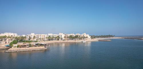 an aerial view of a body of water with buildings at Juweira Boutique Hotel Adult only in Salalah