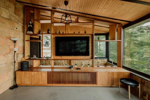 ein Wohnzimmer mit einem großen Fenster und einem TV in der Unterkunft Cedar Scent Guesthouse in Batrun