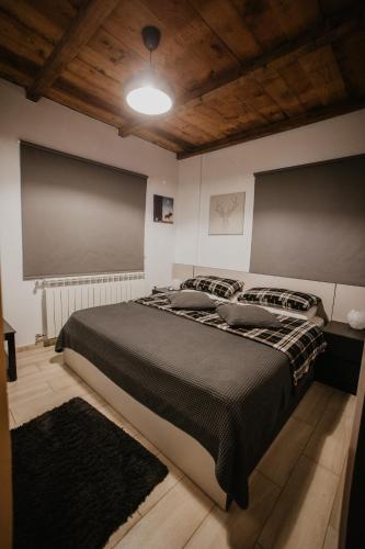 a bedroom with a large bed with a black blanket at Cedar Scent Guesthouse in Batroûn