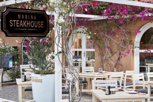 um restaurante com mesas, cadeiras e flores em Captain's Inn Hotel em Hurghada