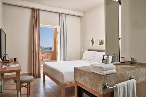 ハルガダにあるCaptain's Inn Hotelのベッドと鏡のあるホテルの部屋
