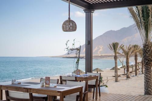 a restaurant on the beach with tables and chairs at Sifawy Boutique Hotel in As Sīfah