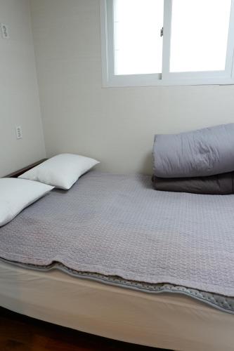 a bed with two pillows on it in a room at Haru The Guesthouse in Andong