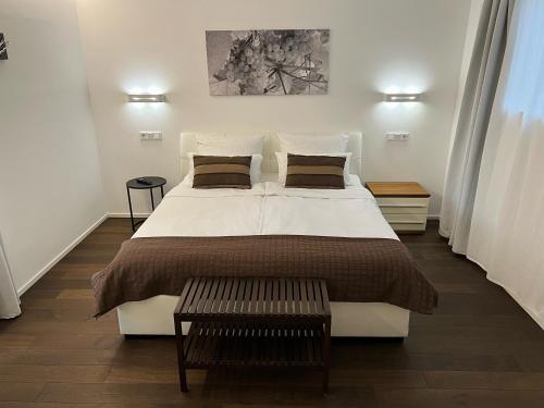 1 dormitorio con 1 cama blanca grande y 2 almohadas en Weingut-Aparthotel Olinger, en Mehring