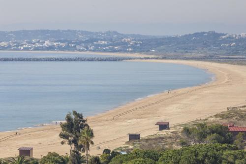 a view of a beach with people walking on it at Pestana Alvor Atlantico Residences Beach Suites in Alvor