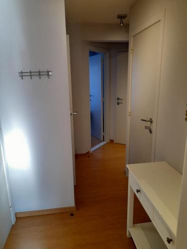 an empty hallway with white walls and wooden floors at Residentie Canada in Blankenberge