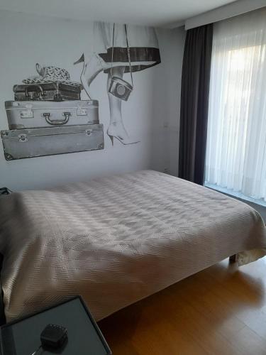 a bedroom with a bed with luggage on the wall at Residentie Canada in Blankenberge