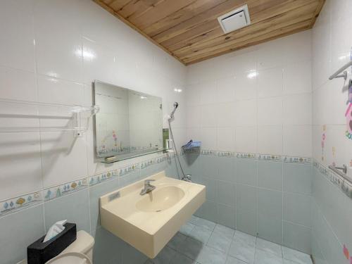 a bathroom with a sink and a mirror and a toilet at Golden Coast 36 - Sea View B&B in Nanwan