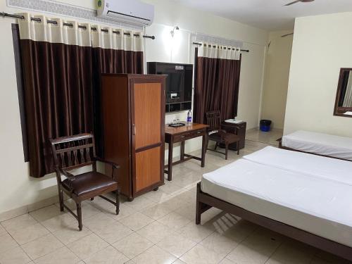 um quarto com uma cama, uma secretária, uma cama e uma cadeira em UPPERCREST RESIDENCY PALA em Pala