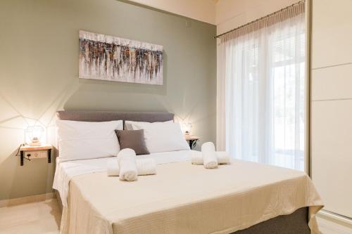 um quarto com uma cama grande e lençóis brancos em Seadrop Suites em Lefkada