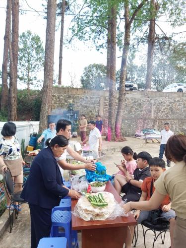 a group of people sitting around a table eating food at Khách sạn Hưng Việt (Măng Đen) in Kon Tum