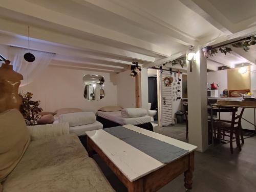 ein Wohnzimmer mit einem Sofa und einem Tisch in der Unterkunft Paris Authentic House studio with green courtyard 12 rue labourse Gentilly 94250 in Gentilly