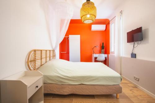- une chambre avec un mur orange et un lit dans l'établissement Maison Giribaldi, à Nice