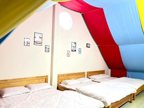 two beds in a room with a large tent at Môn Bạc Home in Da Lat