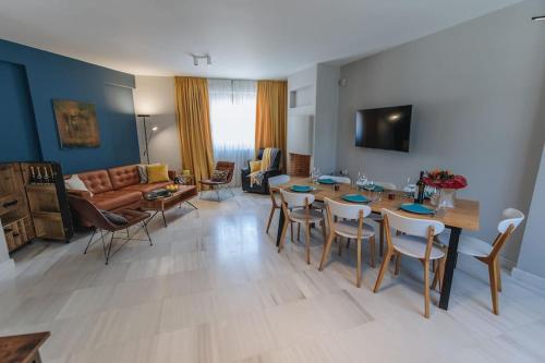 uma sala de estar com uma mesa e cadeiras e um sofá em Varkiza Escape - Amazing Home only 500m from Beach em Vári