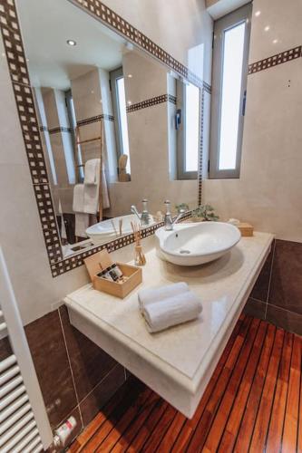 a bathroom with a sink and a large mirror at Varkiza Escape - Amazing Home only 500m from Beach in Vari