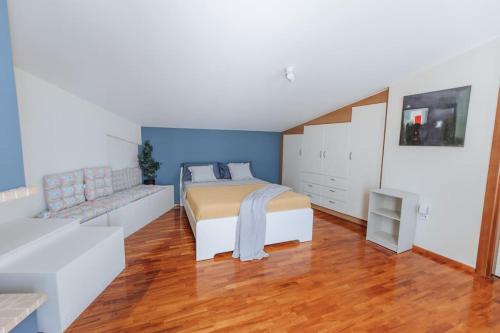 a bedroom with a bed and a couch at Varkiza Escape - Amazing Home only 500m from Beach in Vari