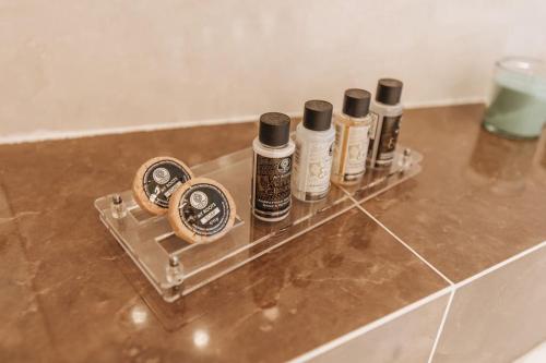 four bottles of essential oils sitting on a shelf in a bathroom at Varkiza Escape - Amazing Home only 500m from Beach in Vari