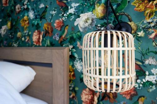a room with a bird cage hanging from a wall at Gîte à la ferme 4 à 6 personnes. in Vieille-Chapelle