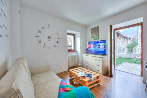 een woonkamer met een bank en een tv bij Casa Umberto - Happy Rentals in Tenno