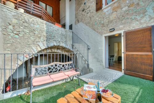a patio with a bench and a brick wall at Casa Umberto - Happy Rentals in Tenno
