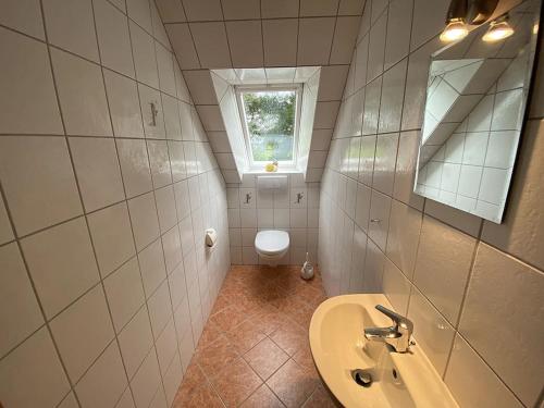 a small bathroom with a sink and a toilet at Ferienwohnung Zur Kuhweide in Dunum