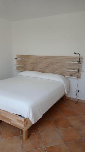 Cama en habitación con cabecero de madera en B&B Denteferro, en Pontecagnano Faiano