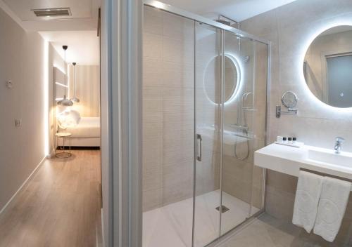 a bathroom with a glass shower and a sink at Hotel Pasarela in Seville
