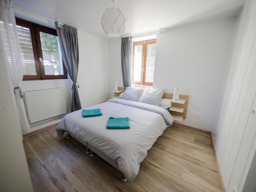 1 dormitorio con 1 cama y 2 toallas verdes en Charmant T2 avec terrasse et place de parking, en Aix-les-Bains