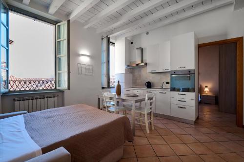 a bedroom with a bed and a table and a kitchen at Domus Dea Città Alta in Bergamo