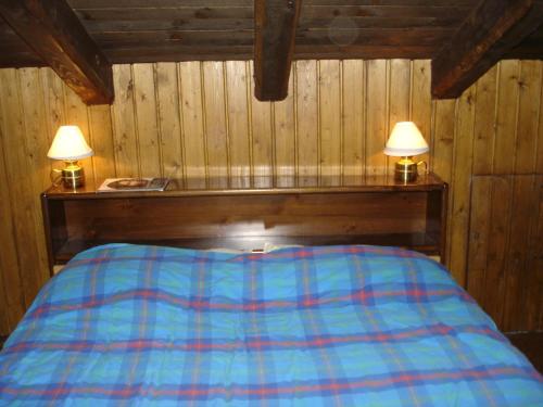 a bedroom with a bed with two lamps on it at Chalet Chamois in Courmayeur