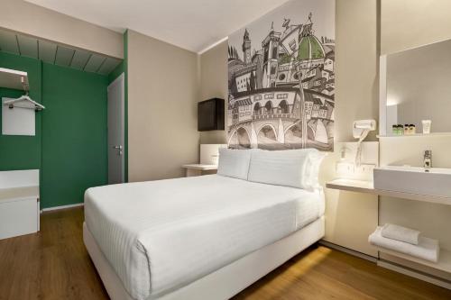 - une chambre avec un lit blanc et un lavabo dans l'établissement Wyndham Garden Florence, à Florence