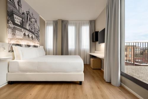 a bedroom with a white bed and a balcony at Wyndham Garden Florence in Florence