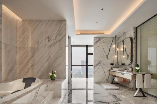 La salle de bains est pourvue d'une baignoire et d'un lavabo. dans l'établissement InterContinental Hangzhou Liangzhu, an IHG Hotel, à Hangzhou